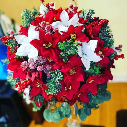 A bouquet of red and white poinsettias on a table.