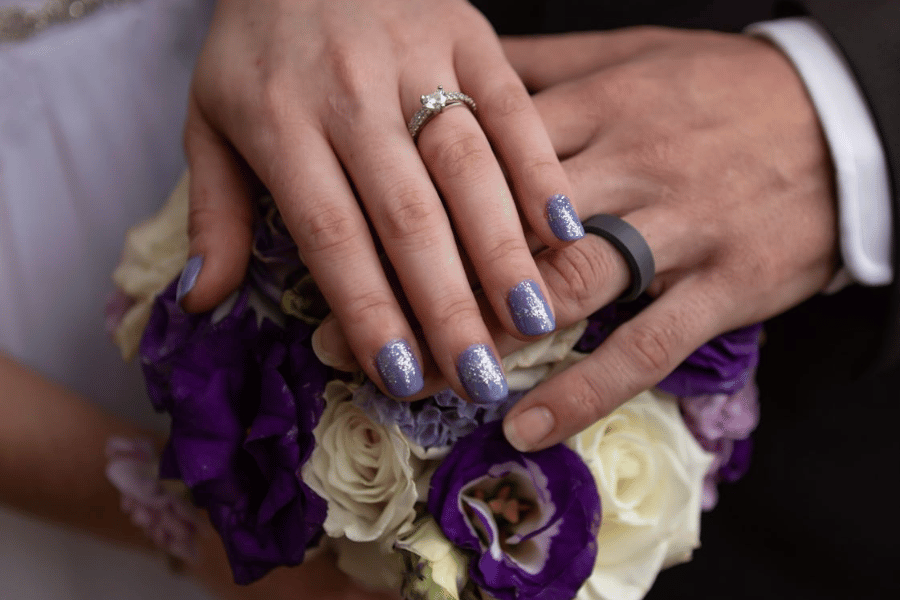 A close up of two hands with wedding rings on